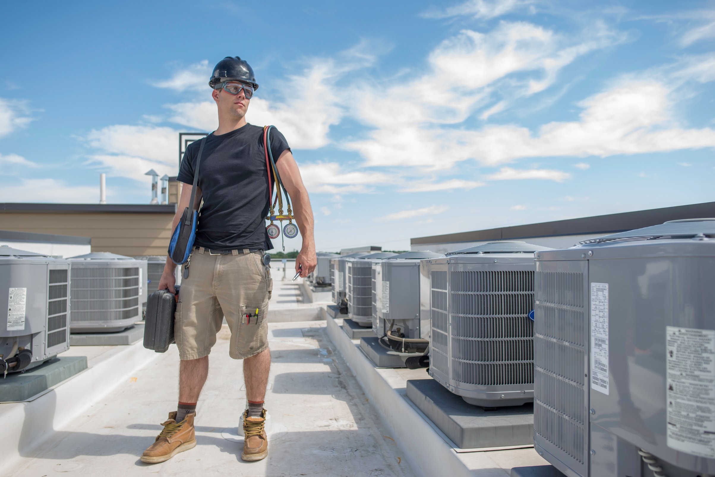 Hvac Tech standing inbetween Condensing Units